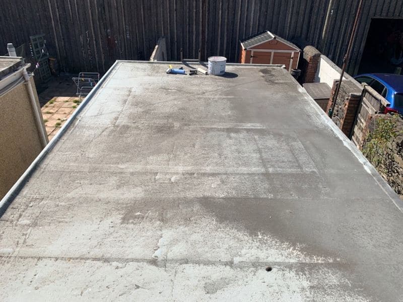 Weathered, patched flat roof on an extension