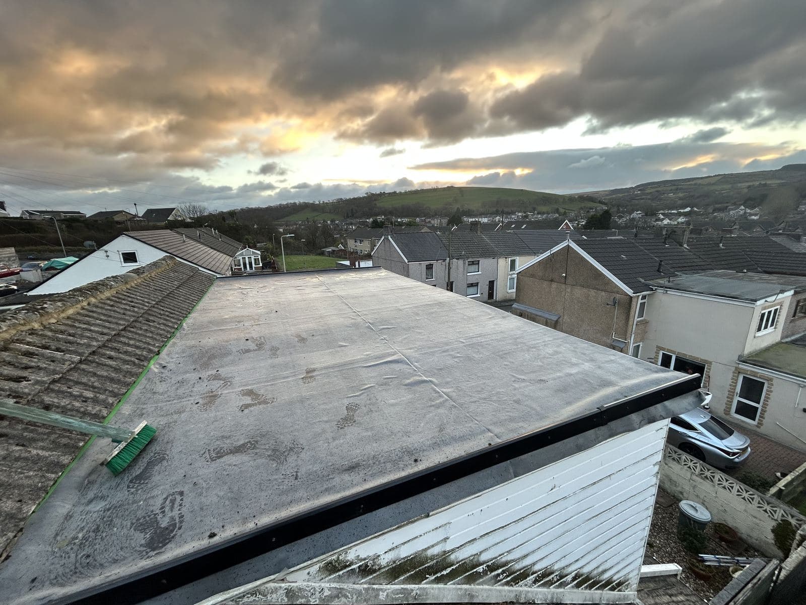 A finished rubber flat roof at sunset, looking over the terraces