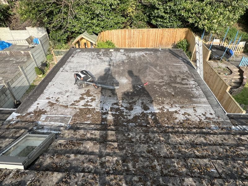 Worn, patched flat roof with two rooflights
