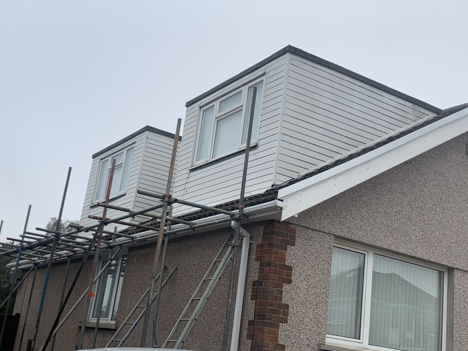 Two dormers with new white cladding, scaffolding still up