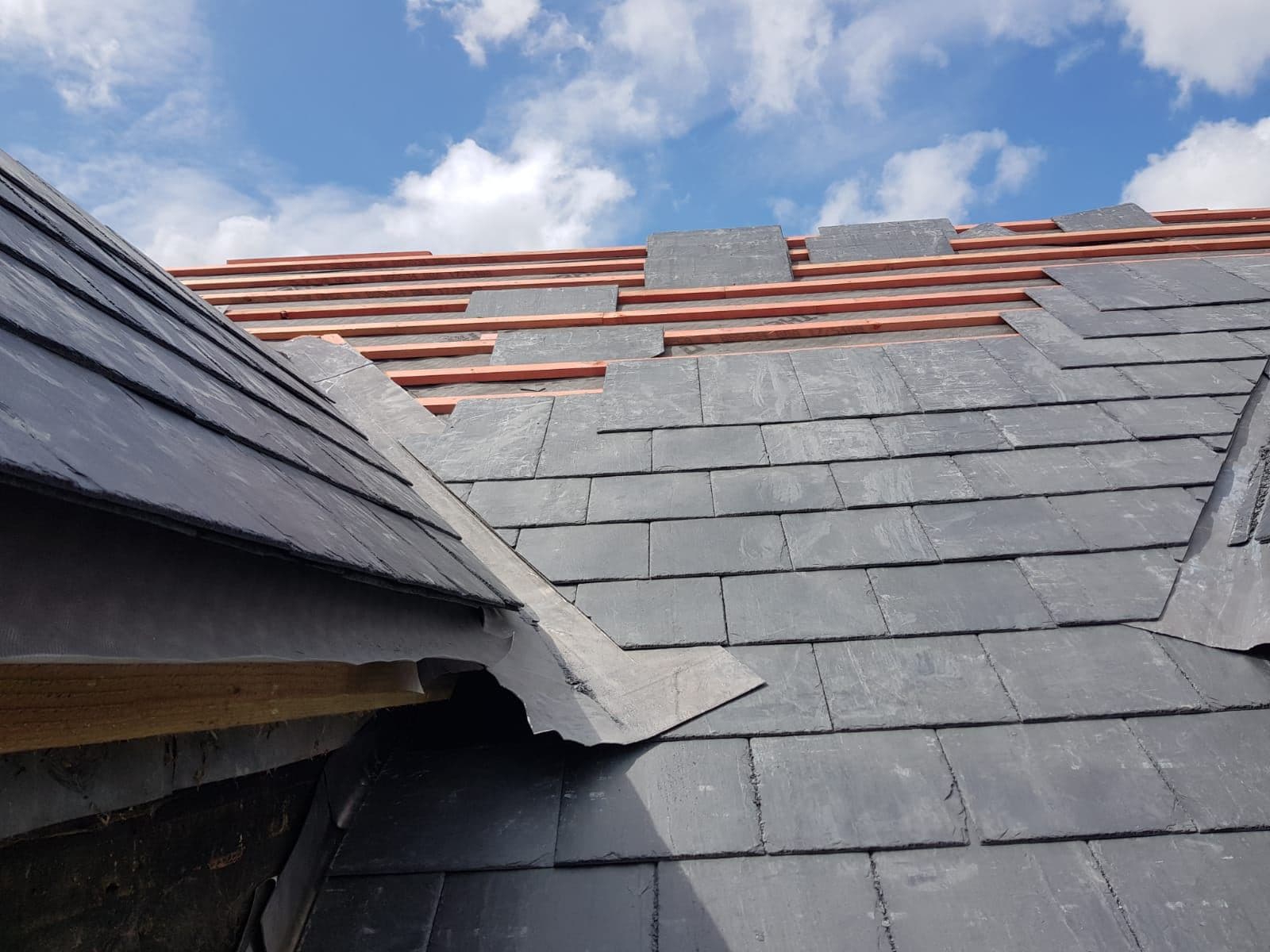 New slates fitted at the eaves of a pitched roof